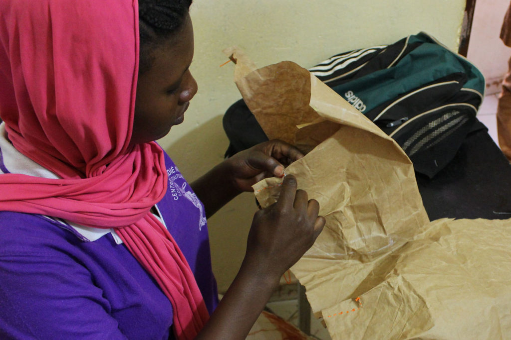 Una noia practica la costura a Mali