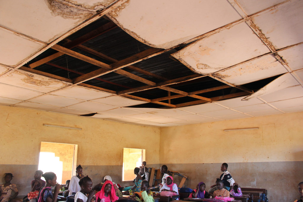 Alumnes de primària a Mali dins d’una aula amb el sostre trencat